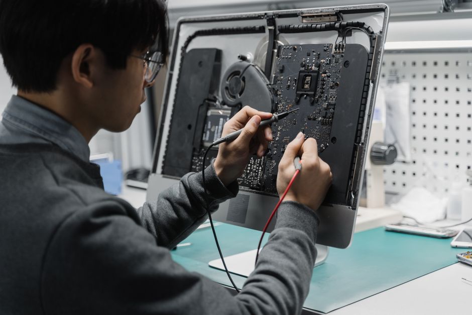 A technician works on a computer motherboard